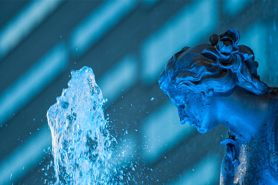 A close up shot of the Fountain Square statue's face, lit up blue