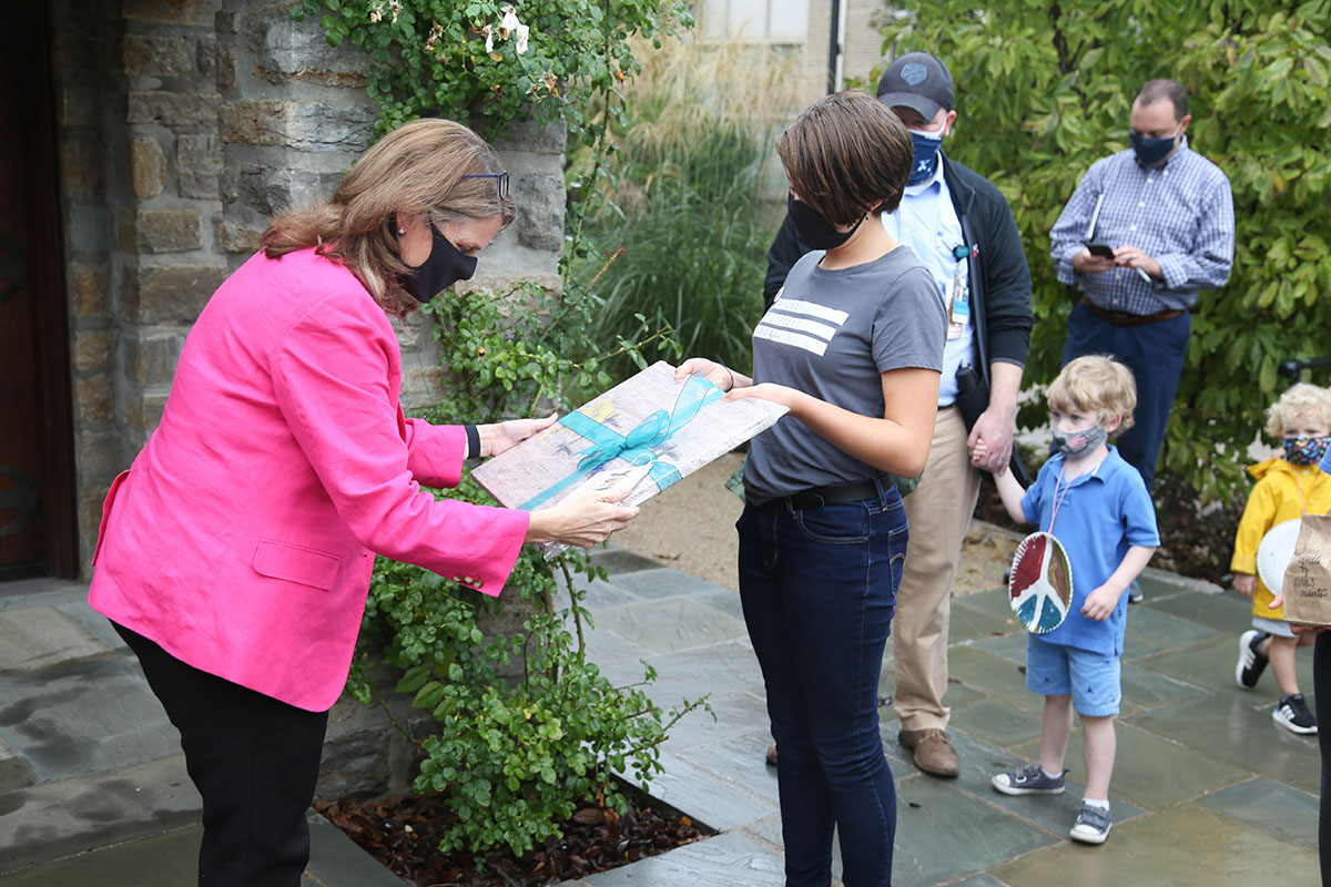 President Hanycz receives a painting as a gift from a Montessori Lab School student.