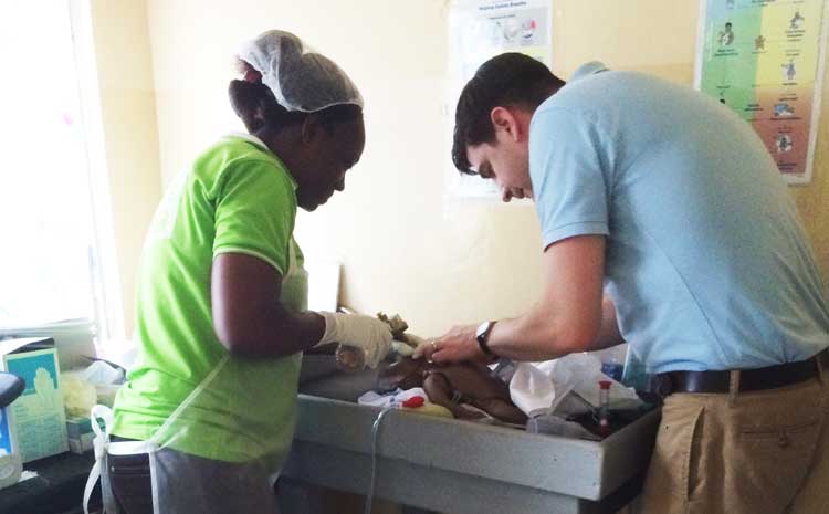 Matt Pellerite helping care for a baby in Ghana.