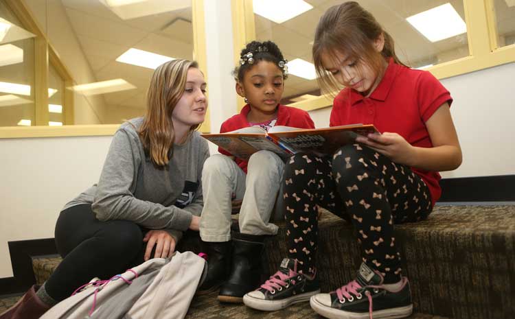 Photo of Courtney Garside reading with children