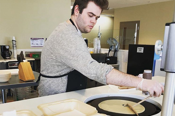 Xavier student making a crepe at FAVEs eatery on campus