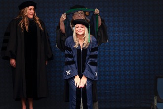 maddie fletcher, student, being hooded at graduation