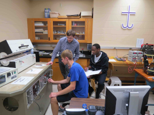 Physics Students working a Project together with their Professor