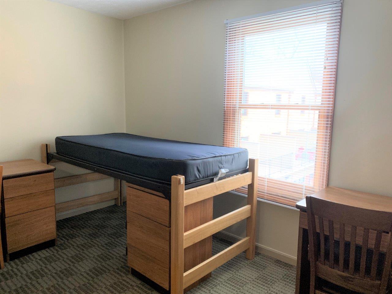 Village Apartments double bedroom showing a bed next to a window