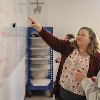 Professor pointing to board 