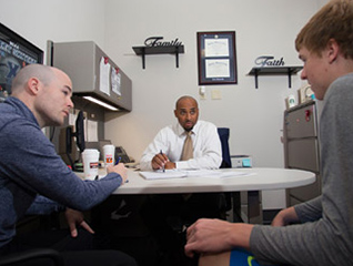 A school counselor talking with a student athlete across a desk