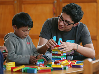 A social worker playing a building blocks game with a child