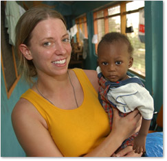 Photo of XU Student Volunteer holding a Child