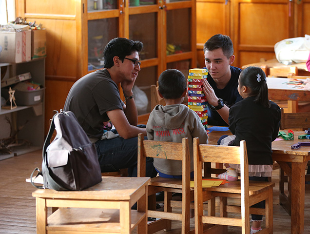 Students earning their degree in special education playing with children in a classroom