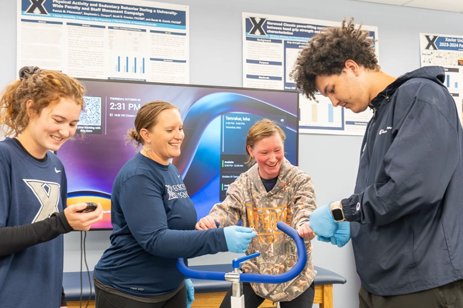 Three students and a professor test out exercise equipment