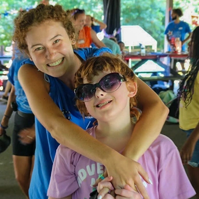 Ellie Shulz smiling with a child