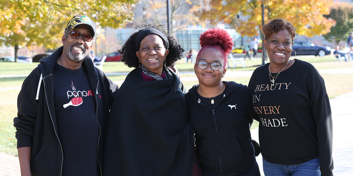 A Xavier family smiling together on campus