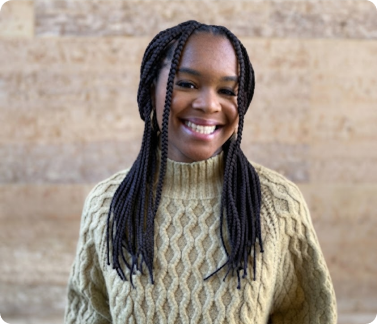 Rachael smiling in front of a stone wall
