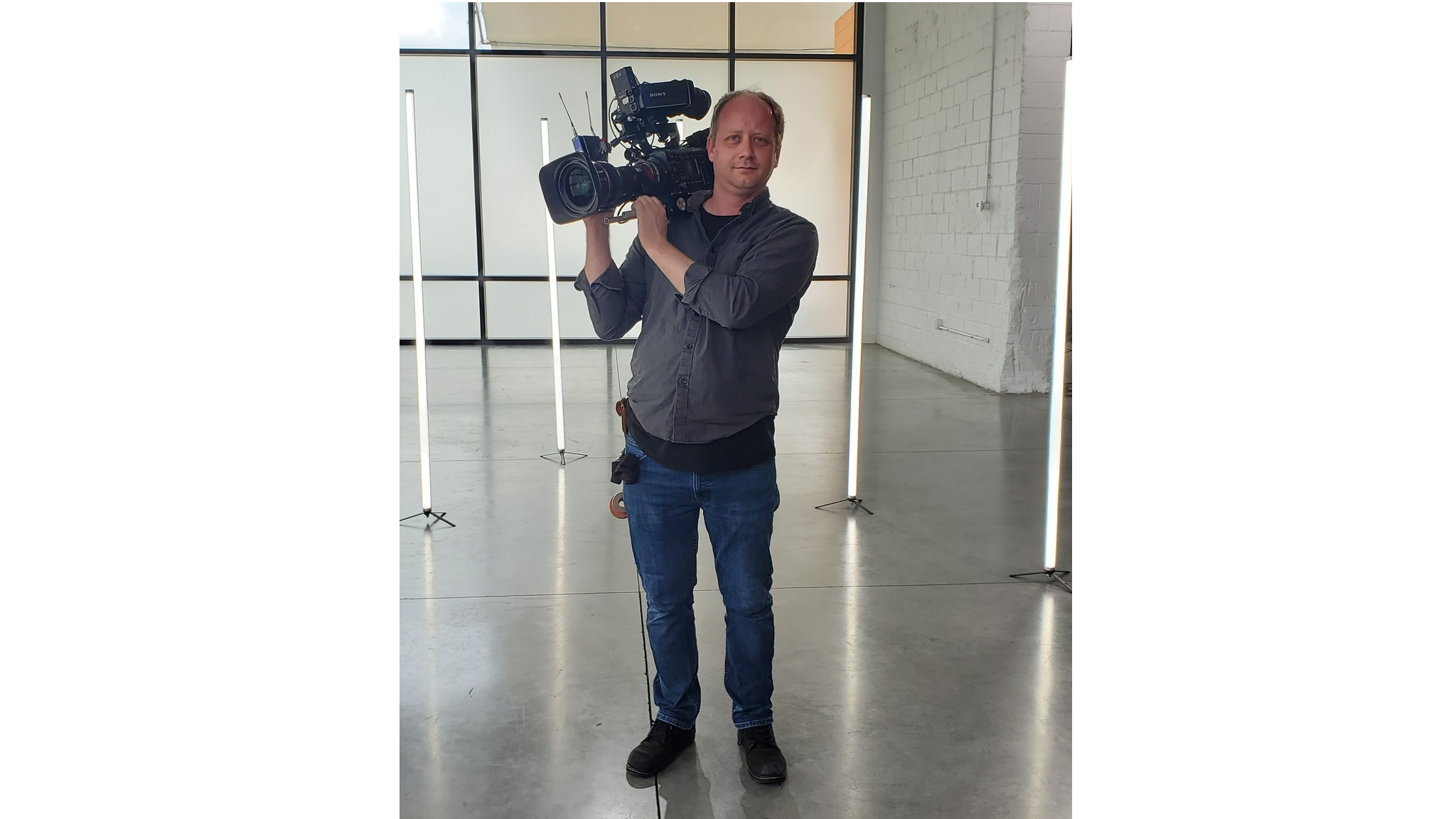 kyle howland with a camera on shoulder