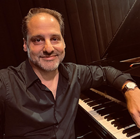 Portrait of Ralph DiSylvestro next to a keyboard