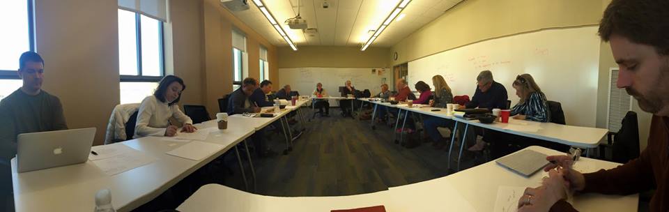 Theology students and faculty working and discussing in a classroom