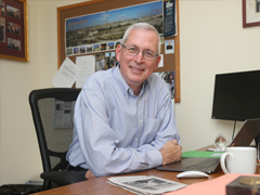 Dr. William Madges, Chair of the Department of Theology, at his desk in his office