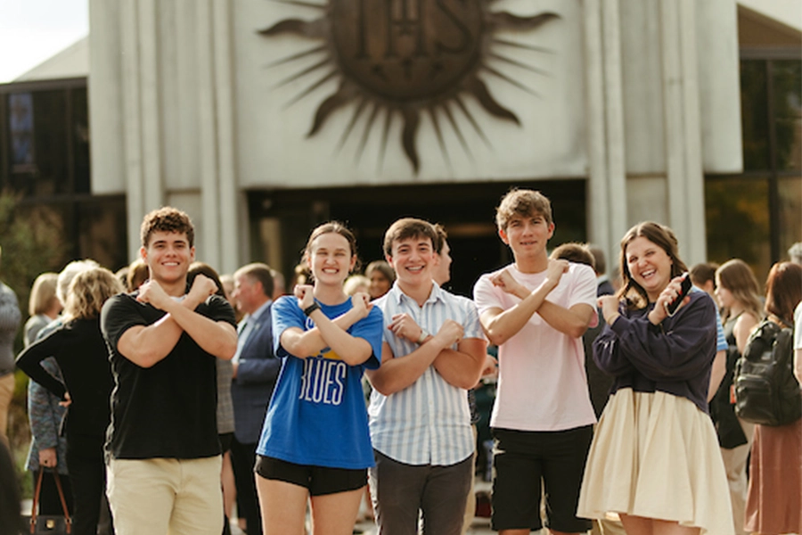 Students on campus crossing their arms into an X