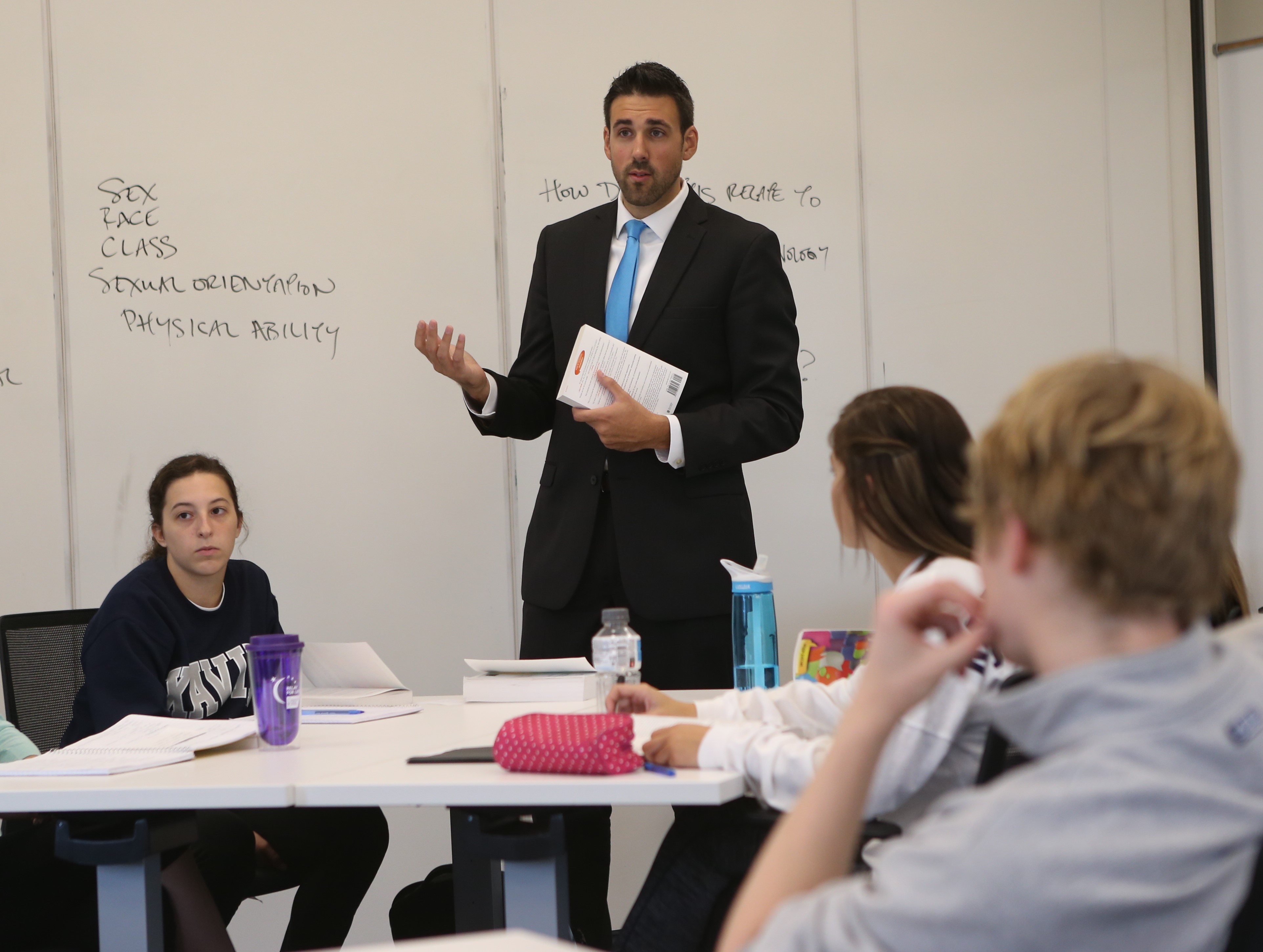 Photo of Professor and Students engaging in a discussion in a Classroom