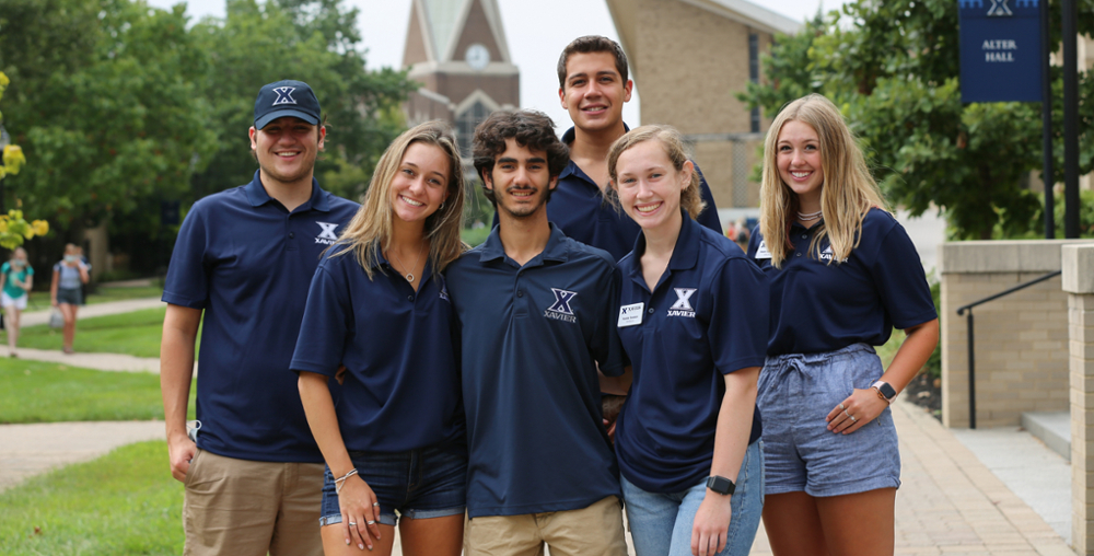 Six Xavier tour guides smiling in a group outside Alter Hall