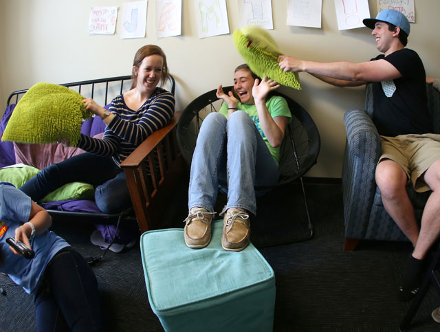 Three Xavier students lounging in a community space in a residence hall on campus
