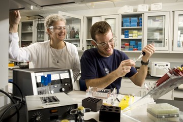 A professor helps a student in a scientific lab classroom setting.