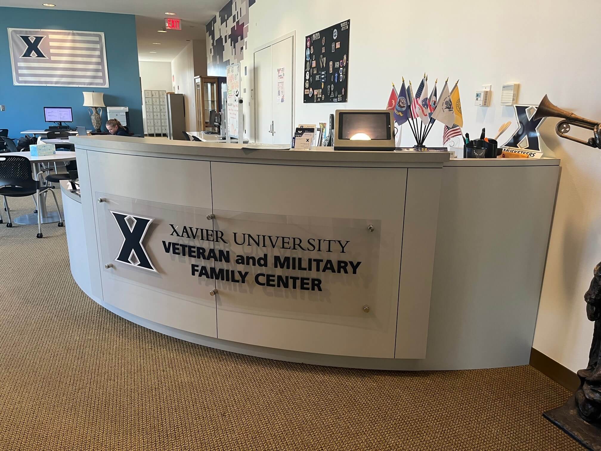 A staff member stands at the welcome desk to the Veteran and Military Family Center on Xavier's campus.