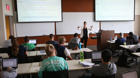 A classroom full of students listening to a teacher